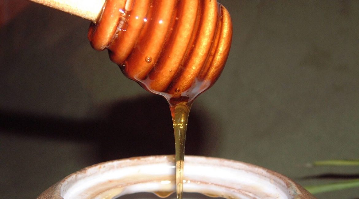 Honey dripping from a hive shaped stick