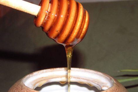 Honey dripping from a hive shaped stick